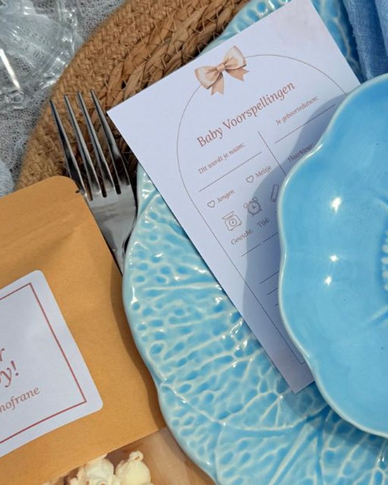 Baby Shower Ideas featuring a blue decorative plate and personalized invitation on a beautifully arranged table.